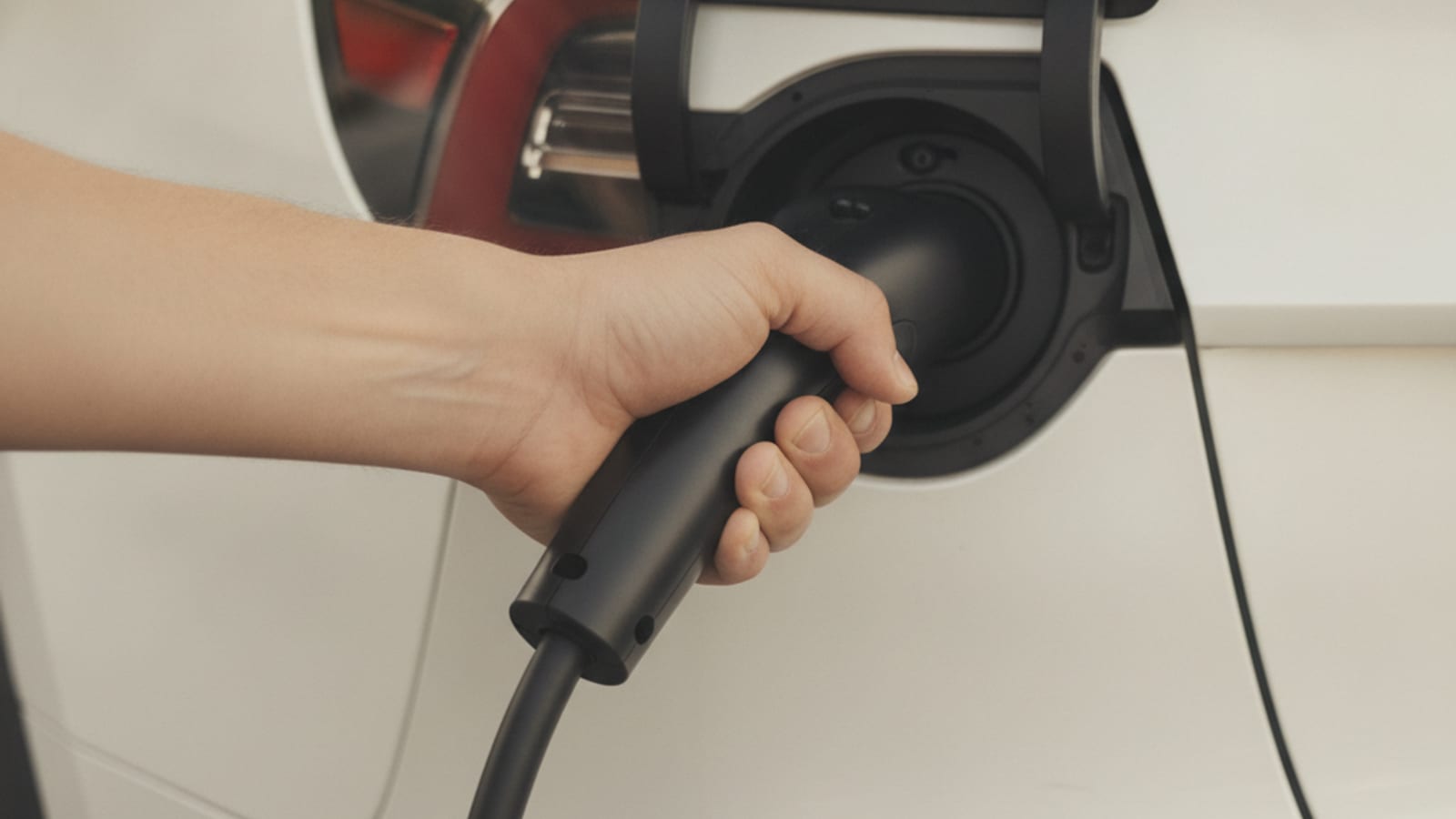 Charge cable locked in an EV port beside a parked car